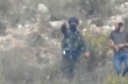 شاهد: جندي إسرائيلي يرشد مستوطنا في استعمال قنبلة غاز ضد الفلسطينيين