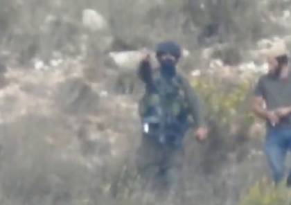شاهد: جندي إسرائيلي يرشد مستوطنا في استعمال قنبلة غاز ضد الفلسطينيين