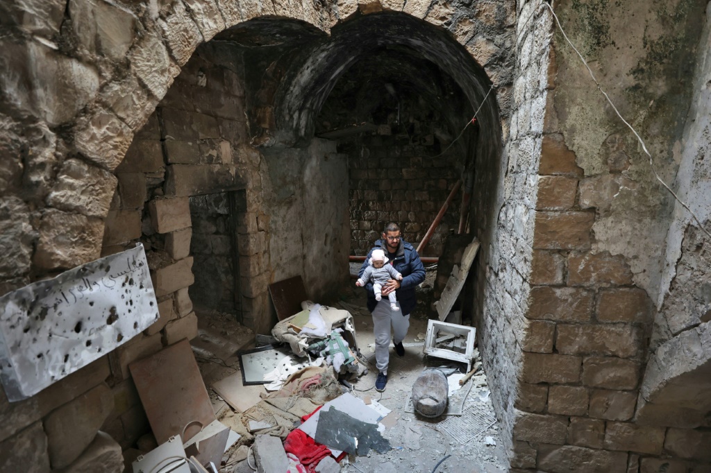 تجمع فلسطينيون لالتقاط صور بين أنقاض المنزل الذي استهدف خلال غارة إسرائيلية في نابلس بالضفة الغربية المحتلة أ ف ب)